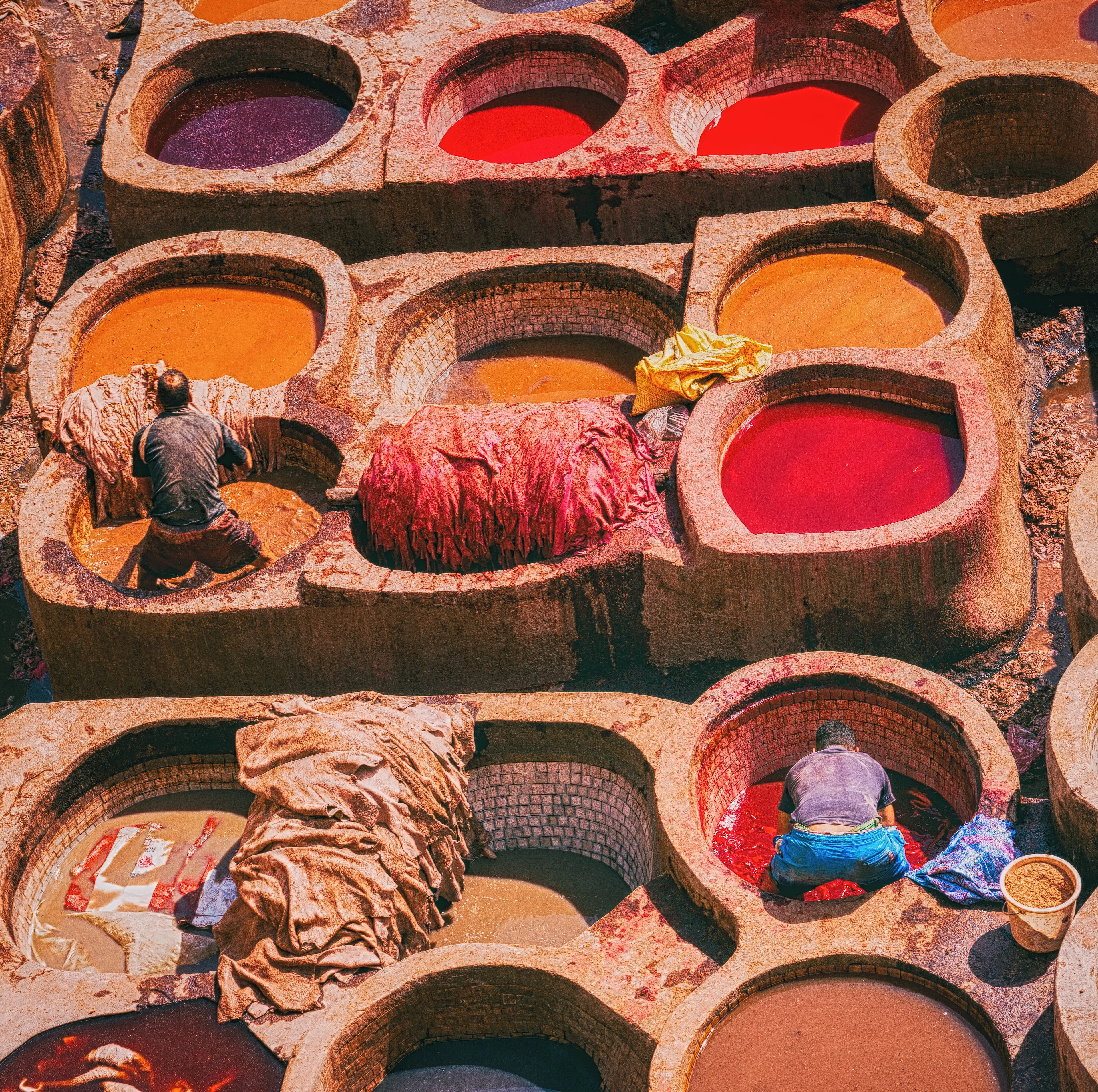 Dyers work among coloured vessels in the medina of Fez.