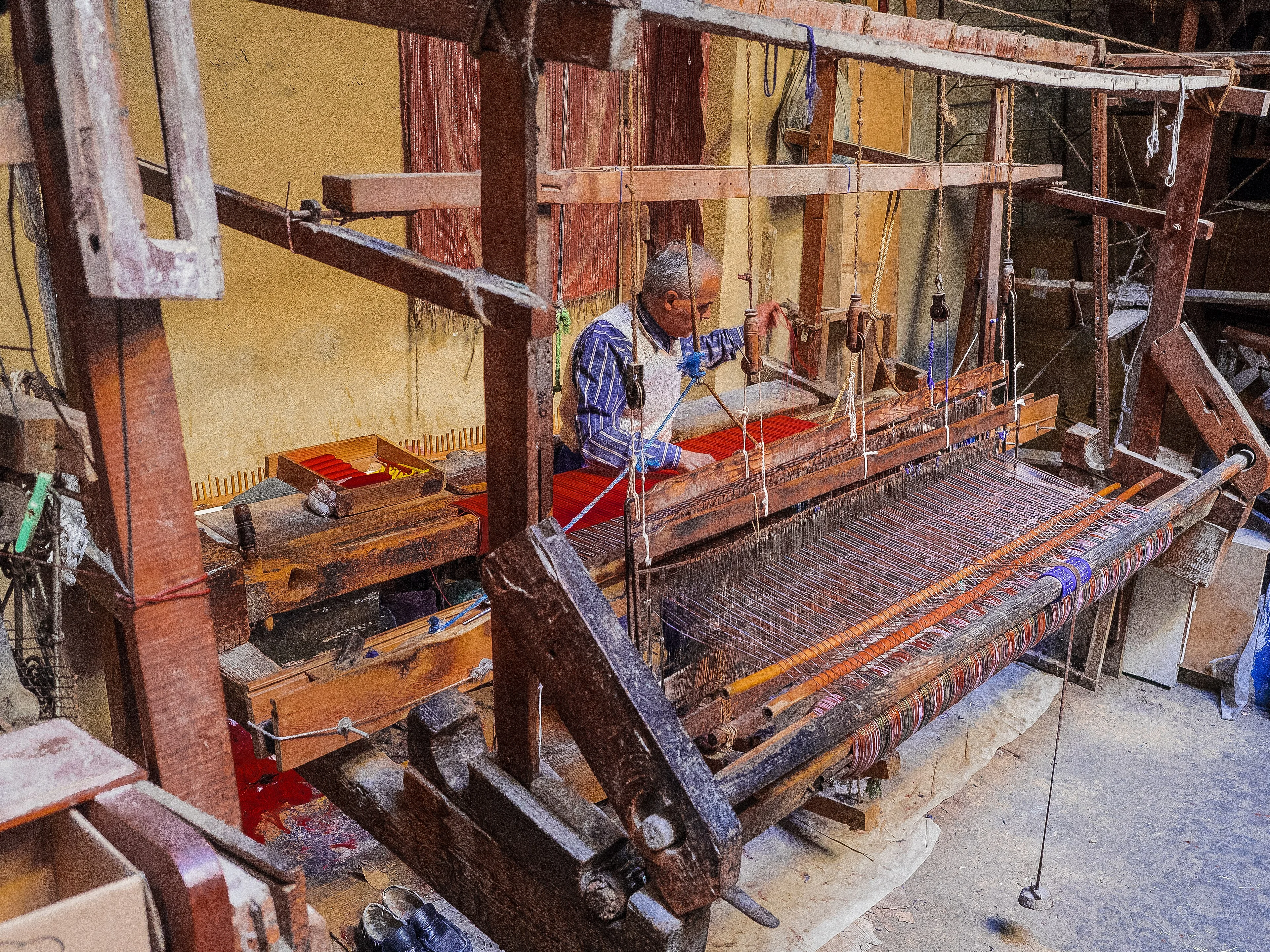 A traditional wooden loom threaded inside a Fez workshop.