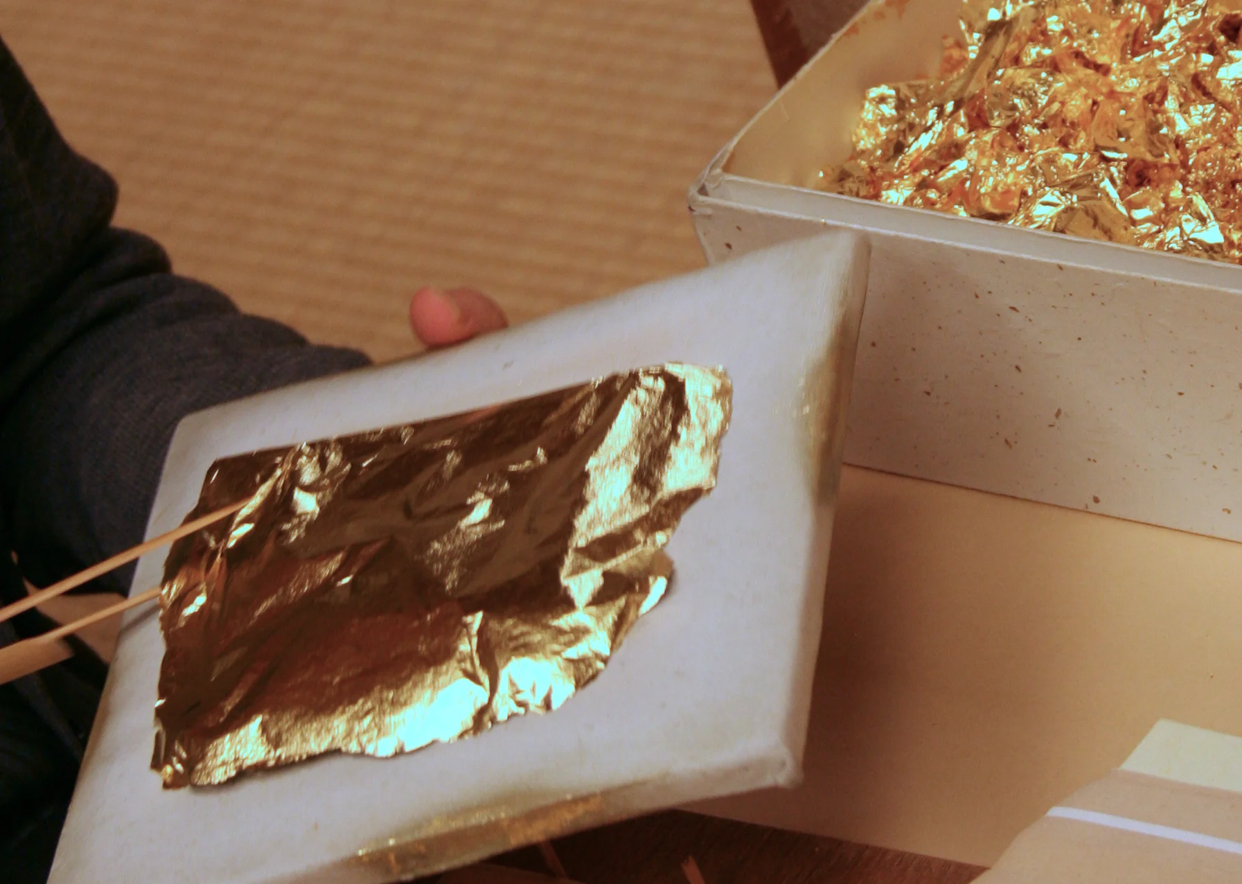 A craftsperson handles gold leaf in a Kanazawa workshop.