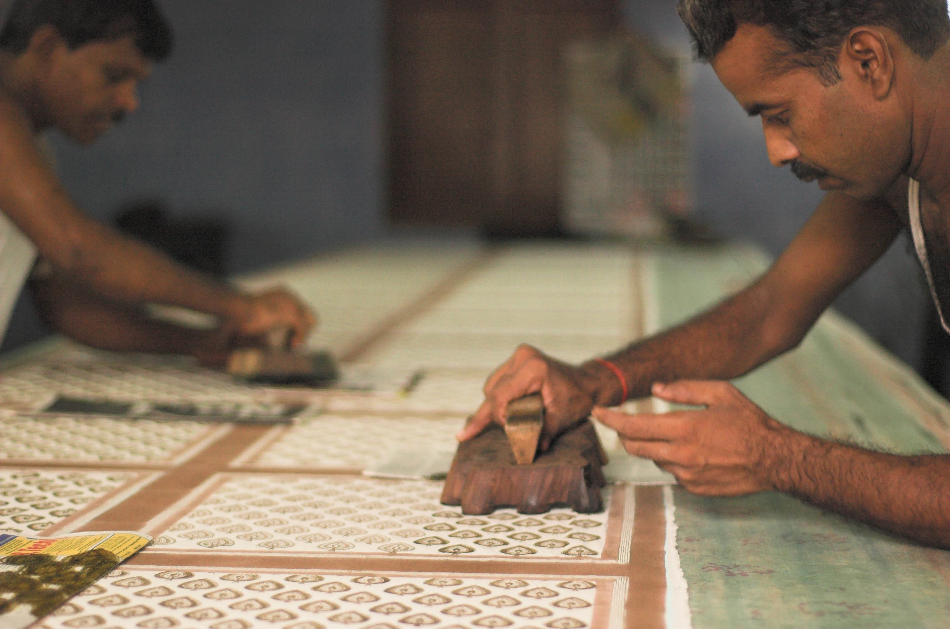 Carved wooden hand-printing blocks arranged beside printed cloth.