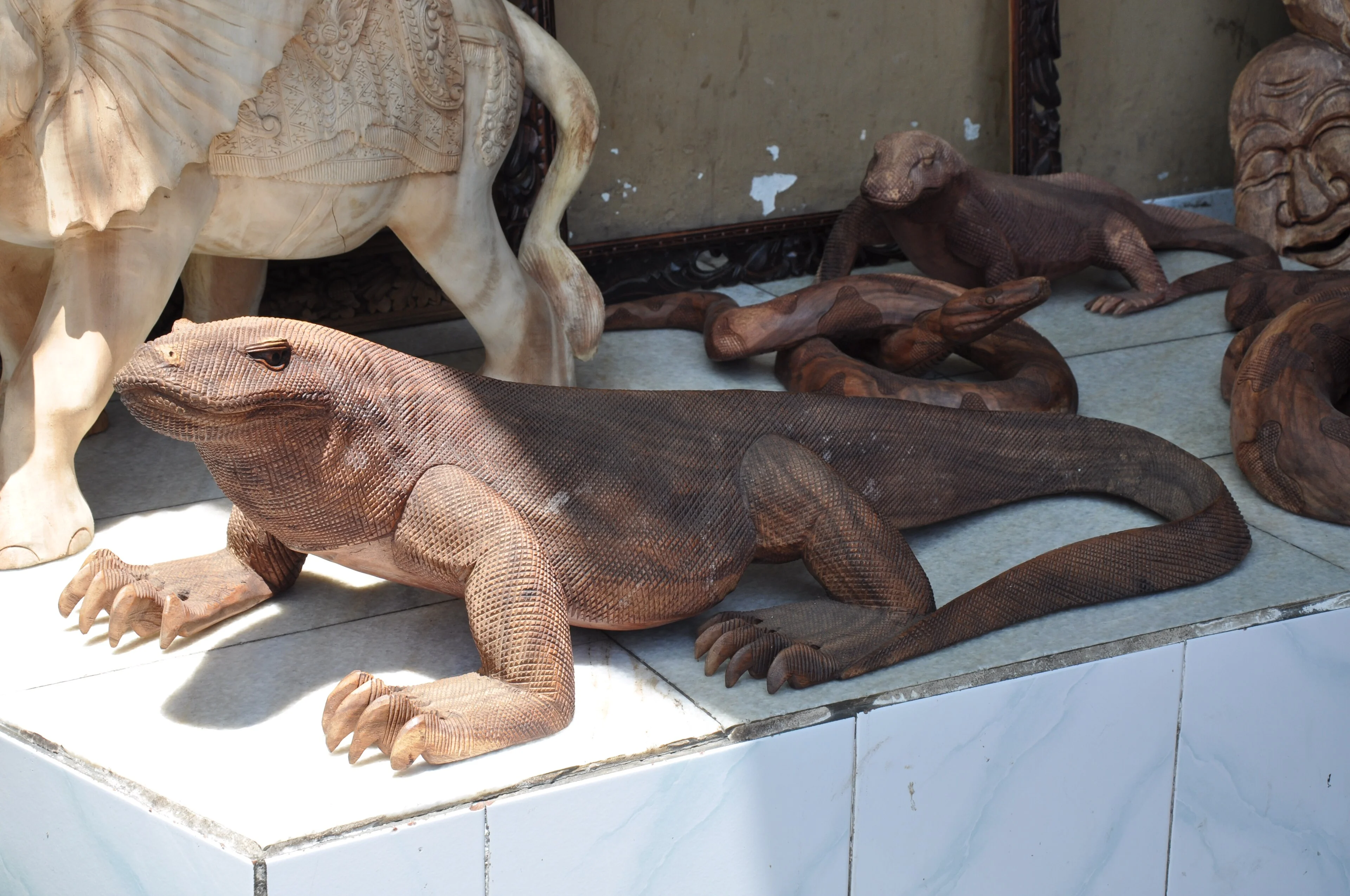 Detailed wooden carvings displayed together in Bali.