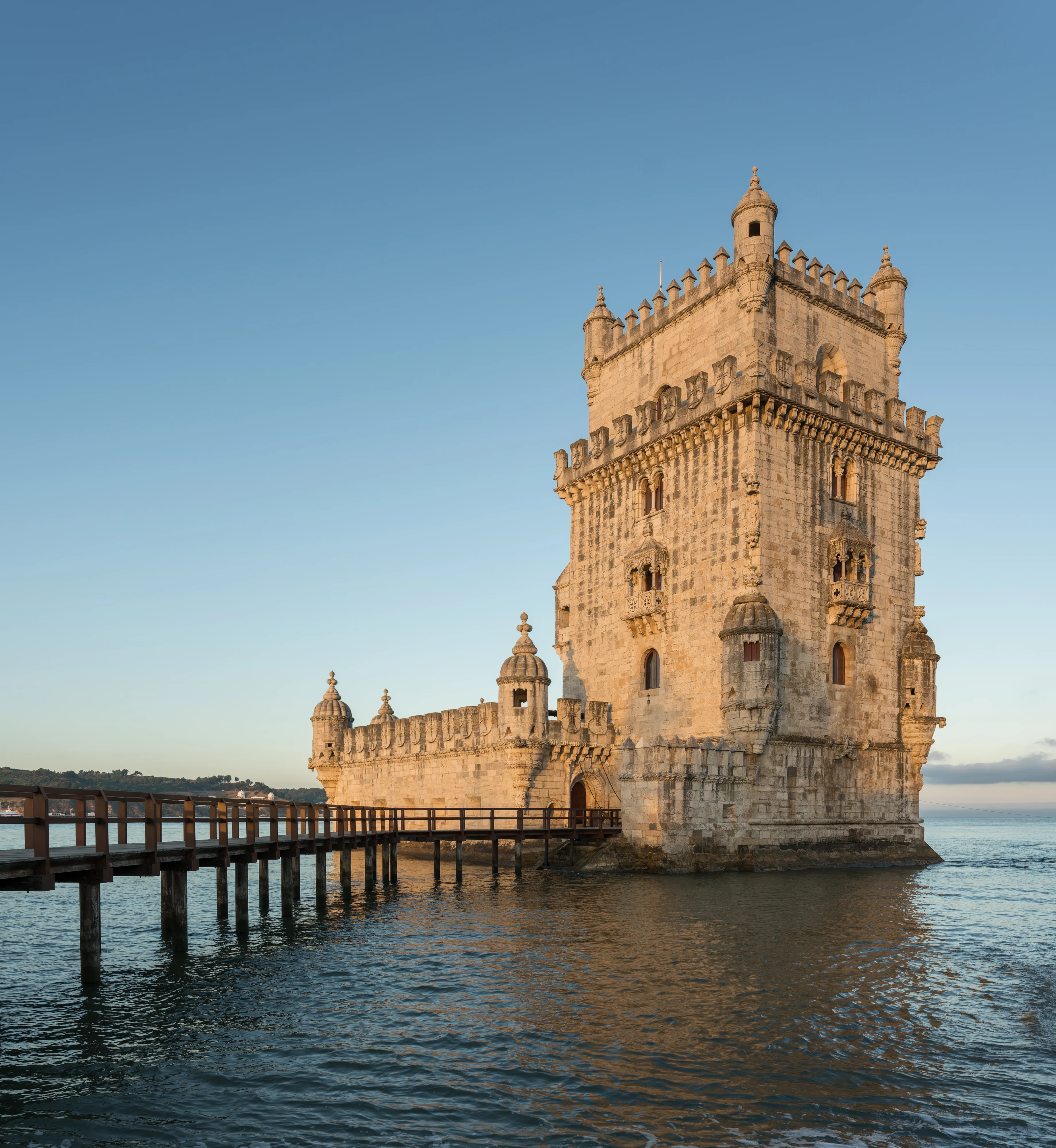 Belem Tower in Lisbon seen in soft pink and gold light at sunrise.