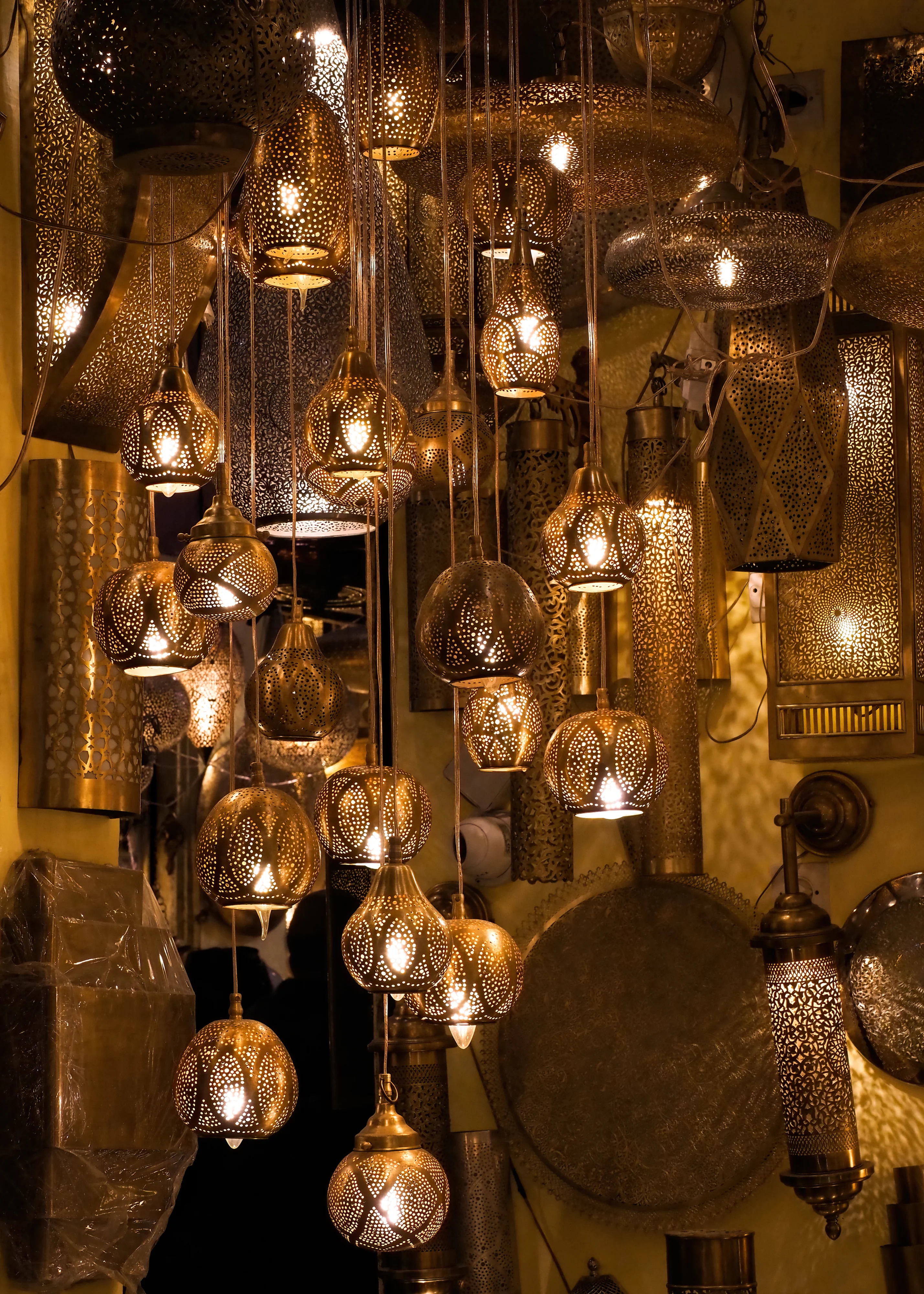 Dozens of pierced metal lanterns hang closely together in a workshop in Marrakech medina.