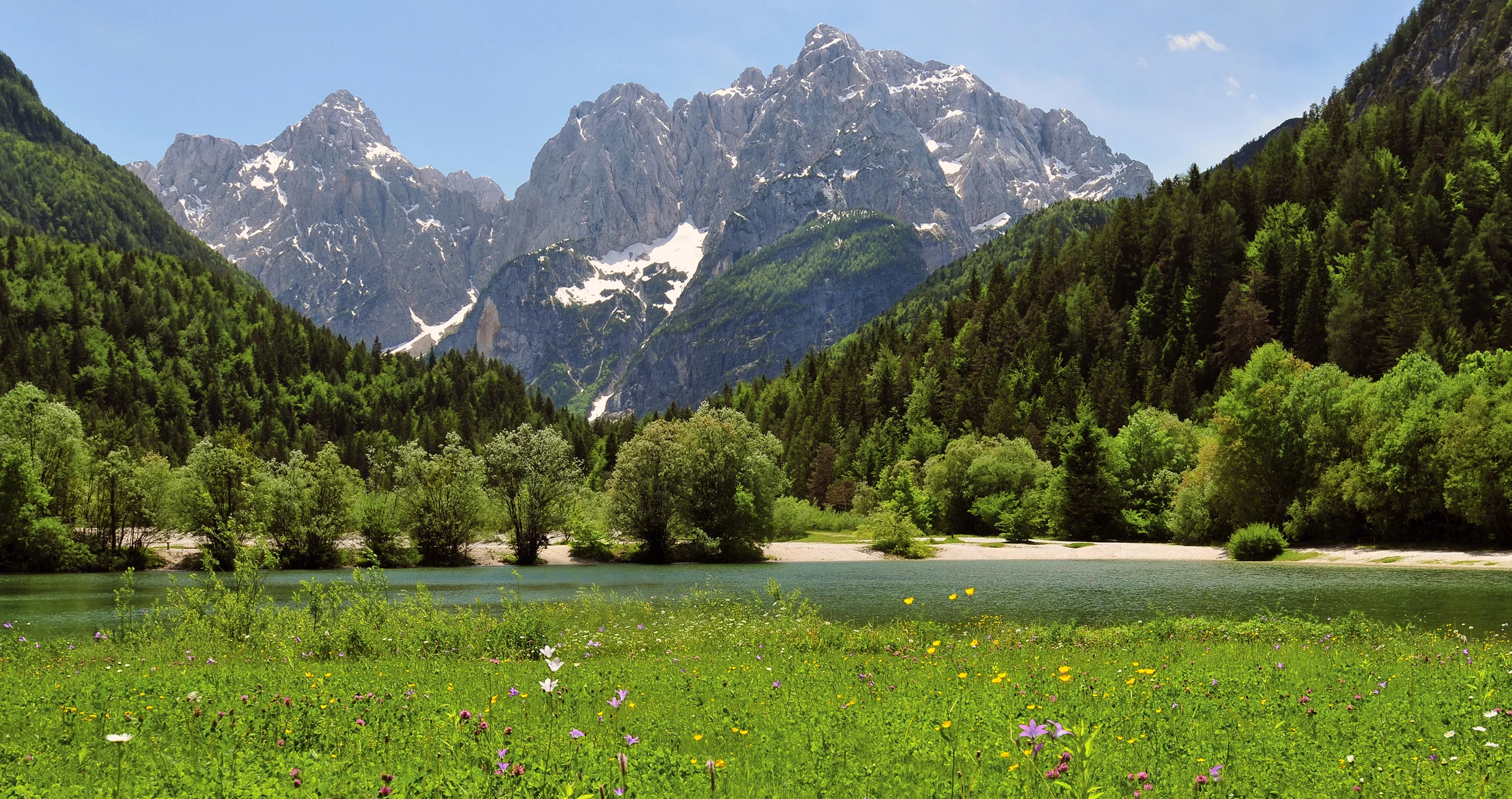 Pale limestone summits of Prisojnik and Razor rise above green Julian Alpine valleys.