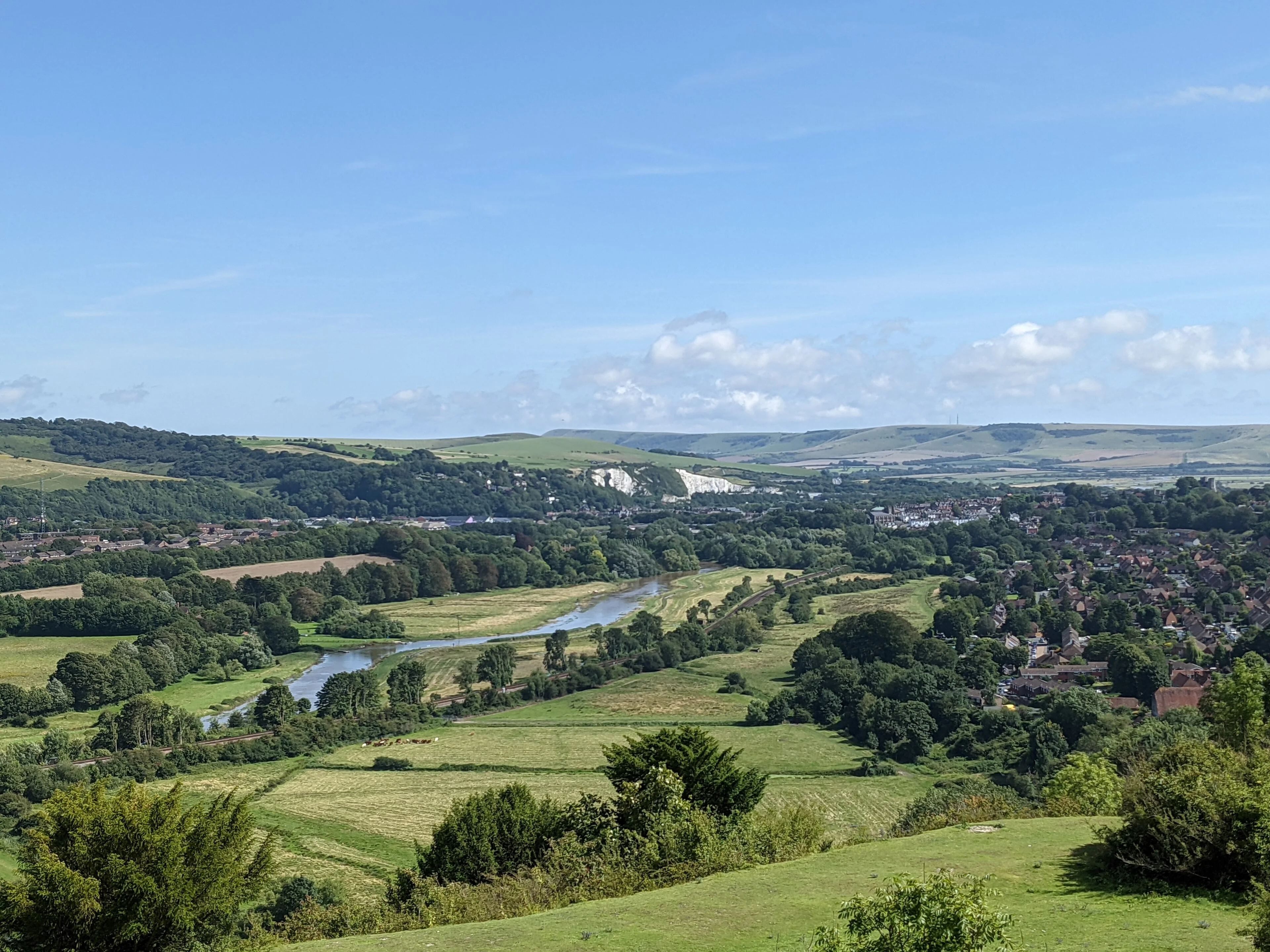Green and gold fields rise toward the rounded South Downs above Lewes.